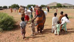 Mothers and Children walk home with mosquito nets