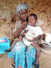 Afia feeding her daughter porridge.