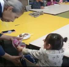 (Before pandemic) Little girl puts on her shoe