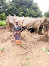 Dona Cecilia in front of her badly damaged house
