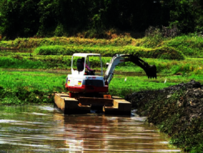 Deweeding and desilting using heavy machinery