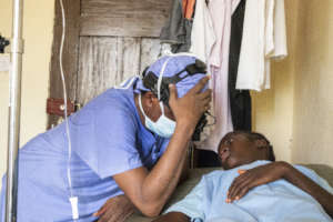 Dr. Lebbie praying with his pediatric patient