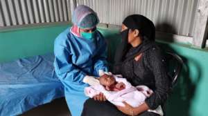 Midwife Rotna with Minara and her baby
