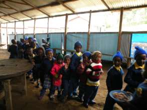 kids eat in a makeshift dining shelter