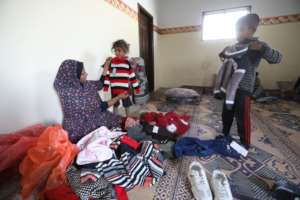 Om Adel dressing her children in new, warm clothes