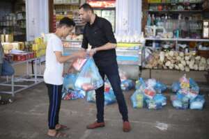 Families picking up food bags from a local store