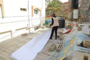 Volunteers covering leaking roofs with sheets
