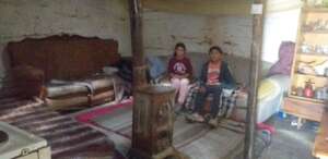 Ana and Embrah sitting on their old furniture.
