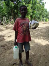 Boy carries food and water to family