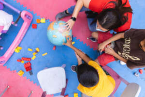 A child shows us his recent journey on a globe.