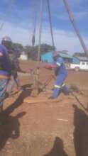 Builders repairing the bore hole at the school