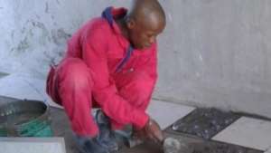 A trainee learning to lay tile