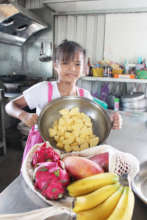 Indigenous Child helping with cutting fruit