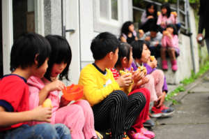 Line of children eating freshly prepared lunch