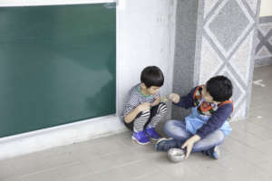 Kid helping smaller kids during meal time