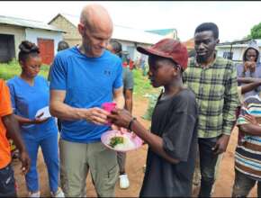 Handling a plate of meal to a street boy