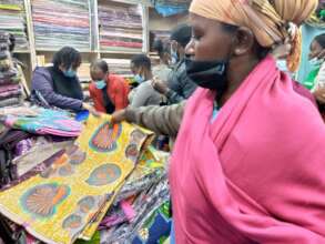 A beneficiary buying vitenge to go and sell