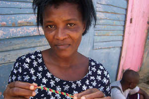 woman holding bracelet she made