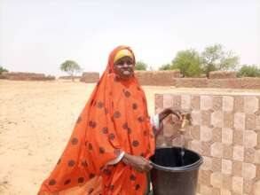 A woman gets water from a tap outside the clinic