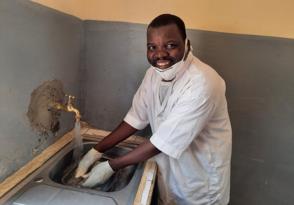 A health care provider washes his instruments