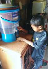Deden helps his mom keep the water filter clean