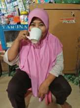 Muniroh enjoys a drink on a hot day