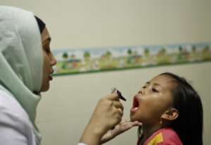 A nurse checks  for tonsillitis.