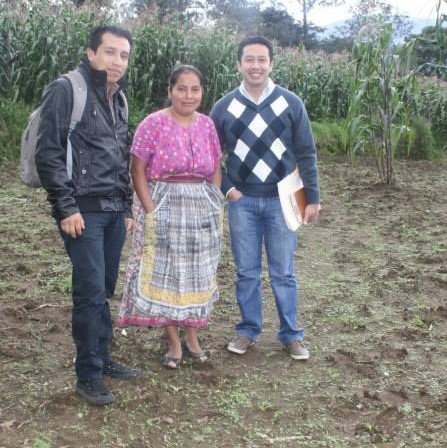 Marta in her potato field with loan supervisors.