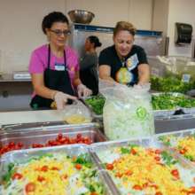 Volunteers prepare salad in WCK's Nassau kitchen