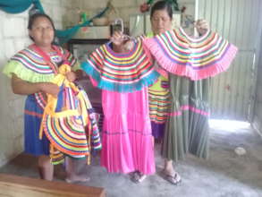 Women show their work in traditional dresses