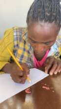 A sister learning to write in Aftercare