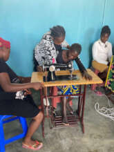 A woman learns to use the manual sewing machine
