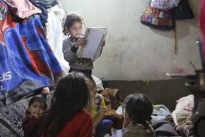 Syrian girl studying in her tent