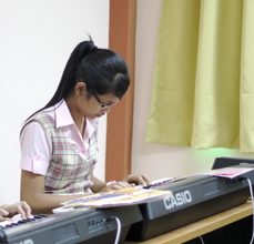 Kuch learning piano at school in Phnom Penh