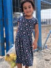 Child receiving fresh food aid from GHNI