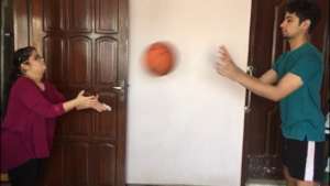 An athlete practicing Basketball with her brother.