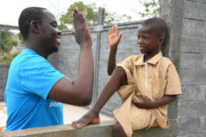 UNICEF staff member with a boy at his new school