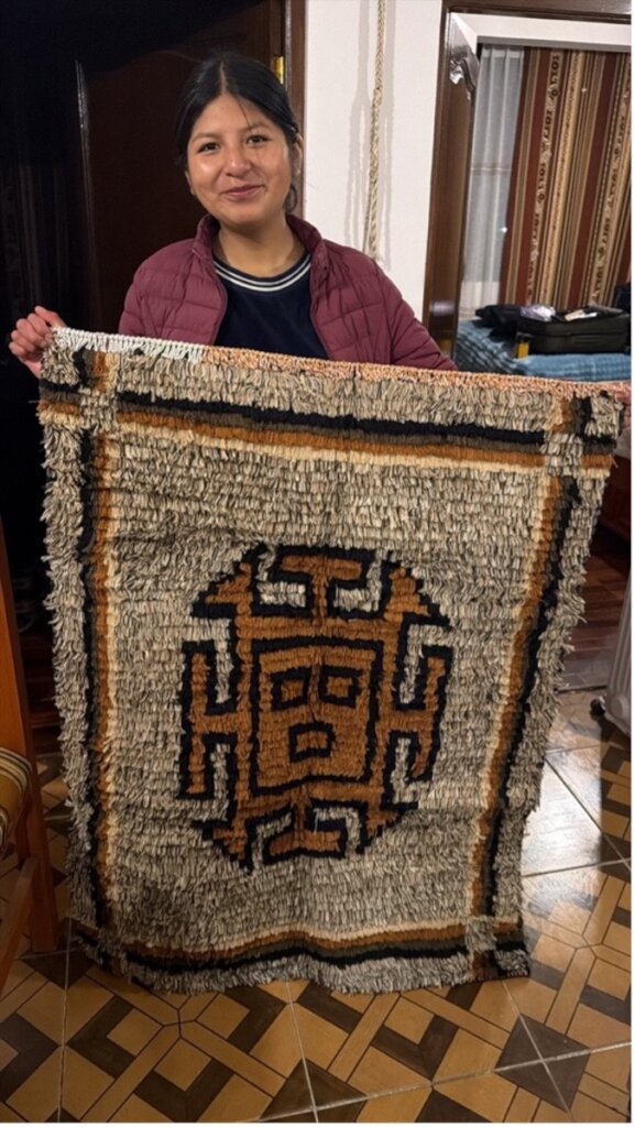 Noelia stops by to show a rug made by her mother.