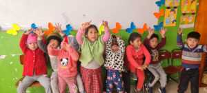 Children wave at Tahuantinsuyo