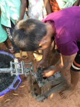 Putting the charcoal sludge in the hand-powered ma