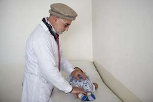 An AIL Doctor examines an infant