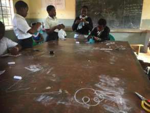 Girls at Minga learning how to make reusable pads