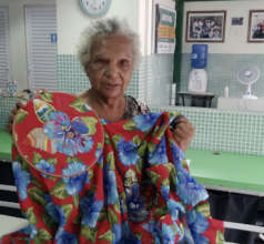 Maria Lucia with a sample of her embroidery