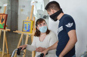 Brasilia talks to a visitor about her painting