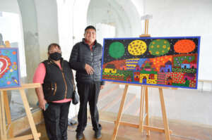 Jorge Luis & his mom next to one of his canvases
