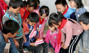 Students at Anla school practice brushing teeth