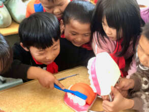 Students in Wuding county practice brushing teeth