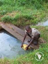 Boy collecting contaminated water for domestic use