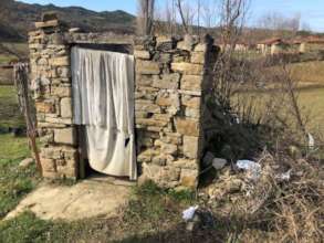 A crumbling outdoor bathroom in Peza