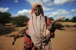 Woman Carrying Child & Firewood